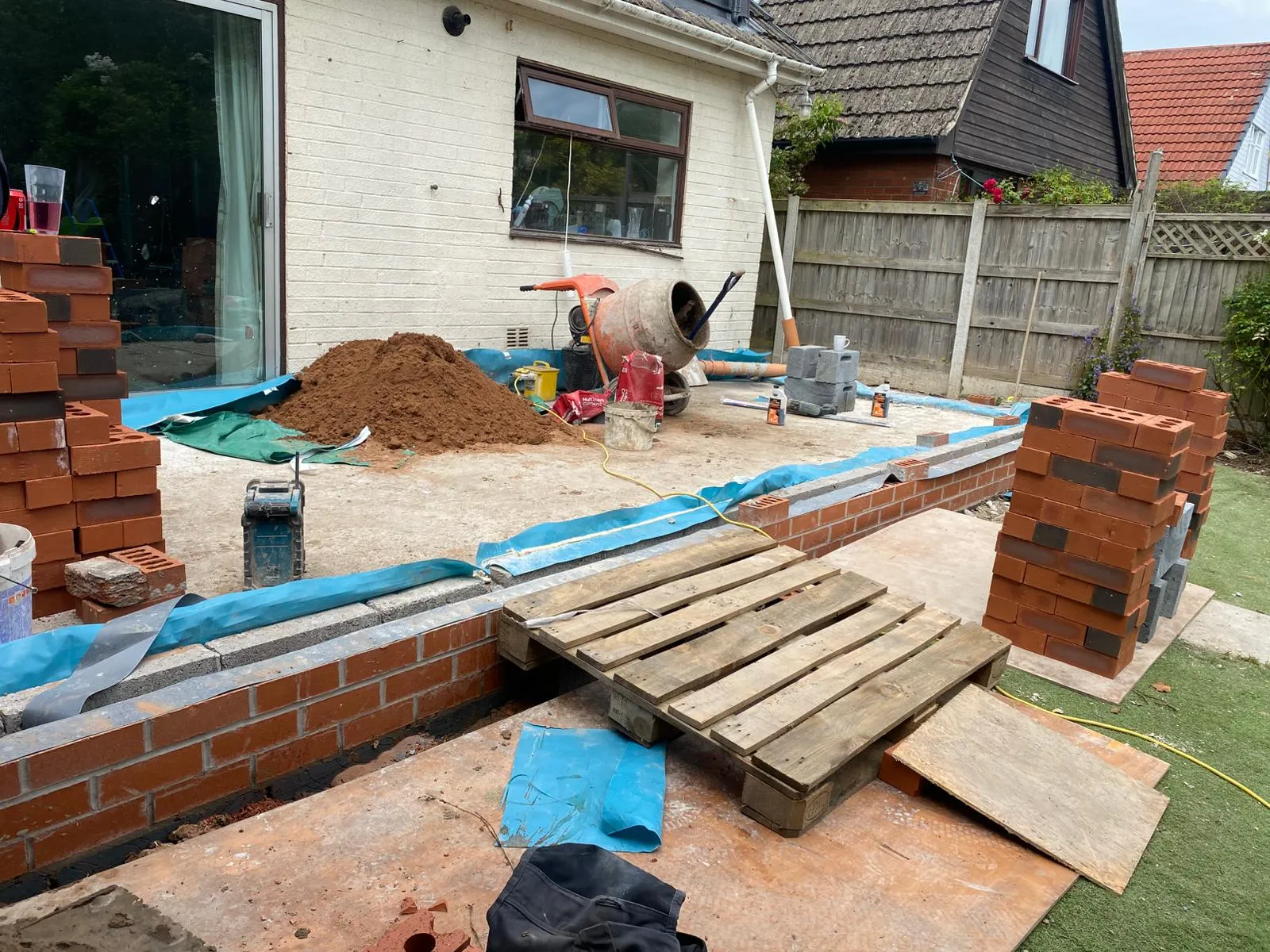 A house being built with a pile of bricks.