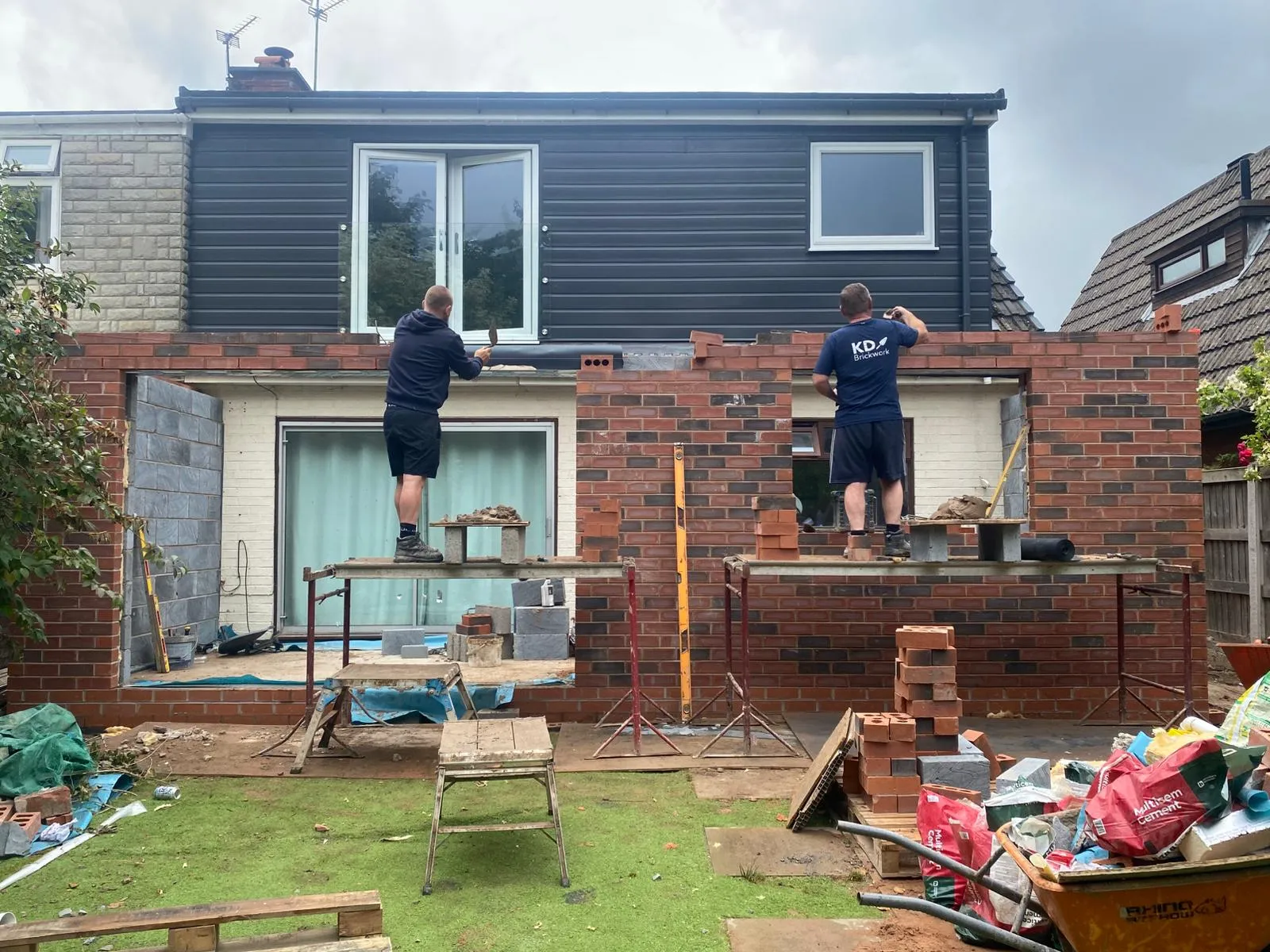 A couple of men standing on top of a roof.